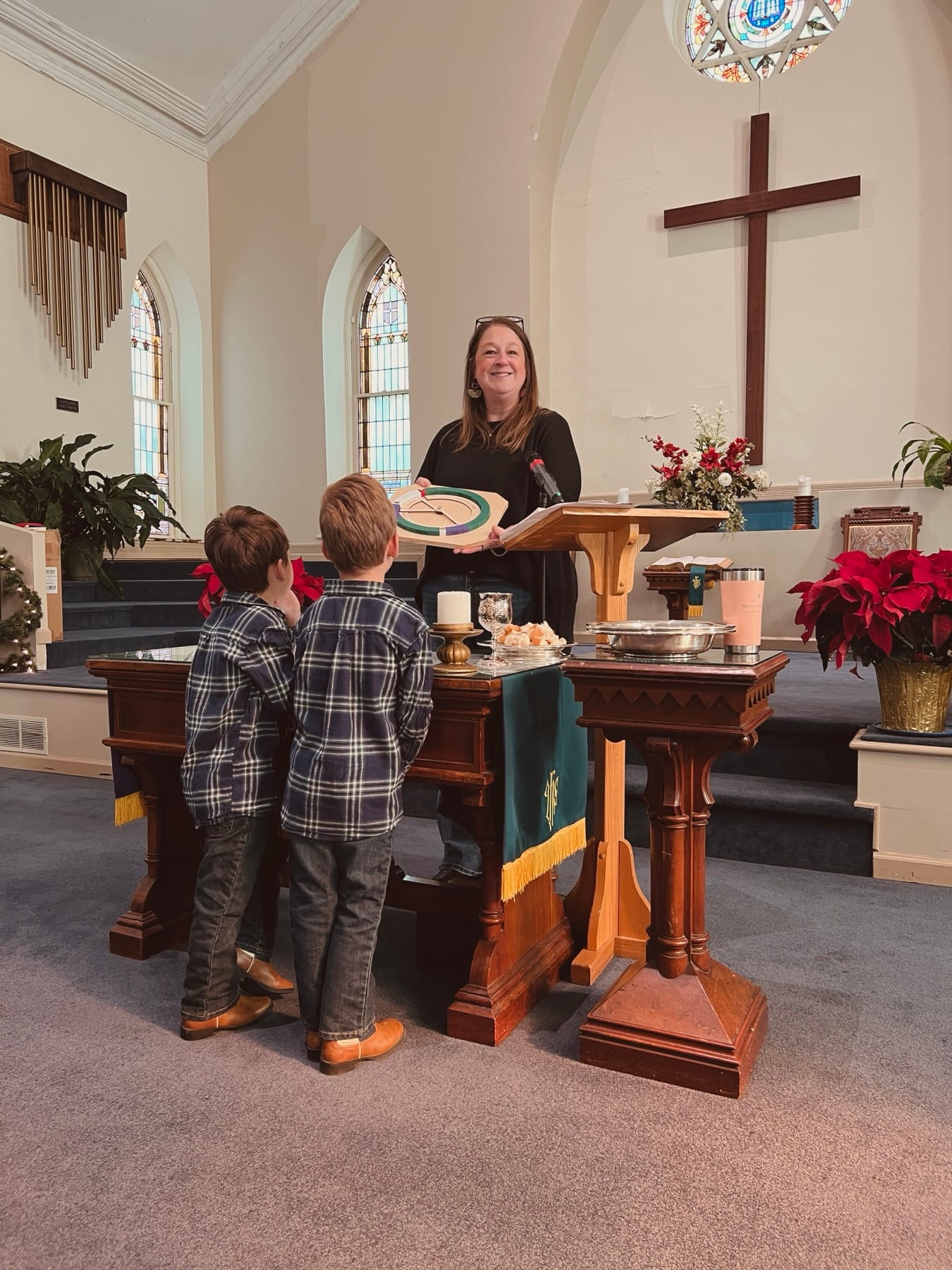 A church leader sharing a children’s moment with two children in the sanctuary